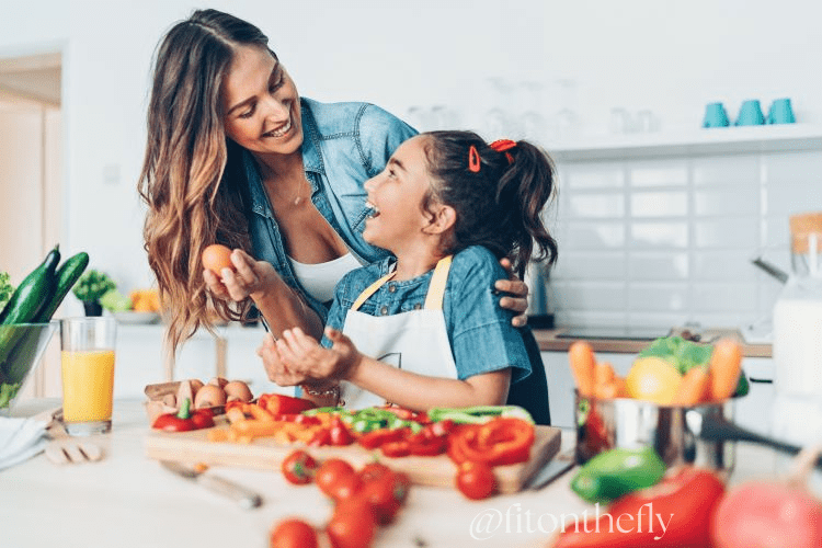 Mother and Daughter Cooking Together with Fresh Vegetables in Kitchen