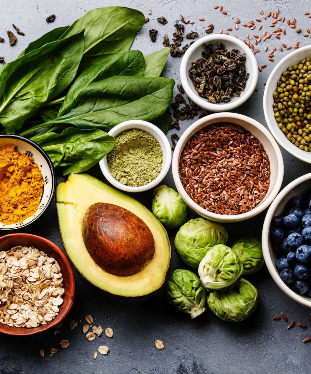Healthy foods: spinach, avocado, seeds, blueberries, spices.