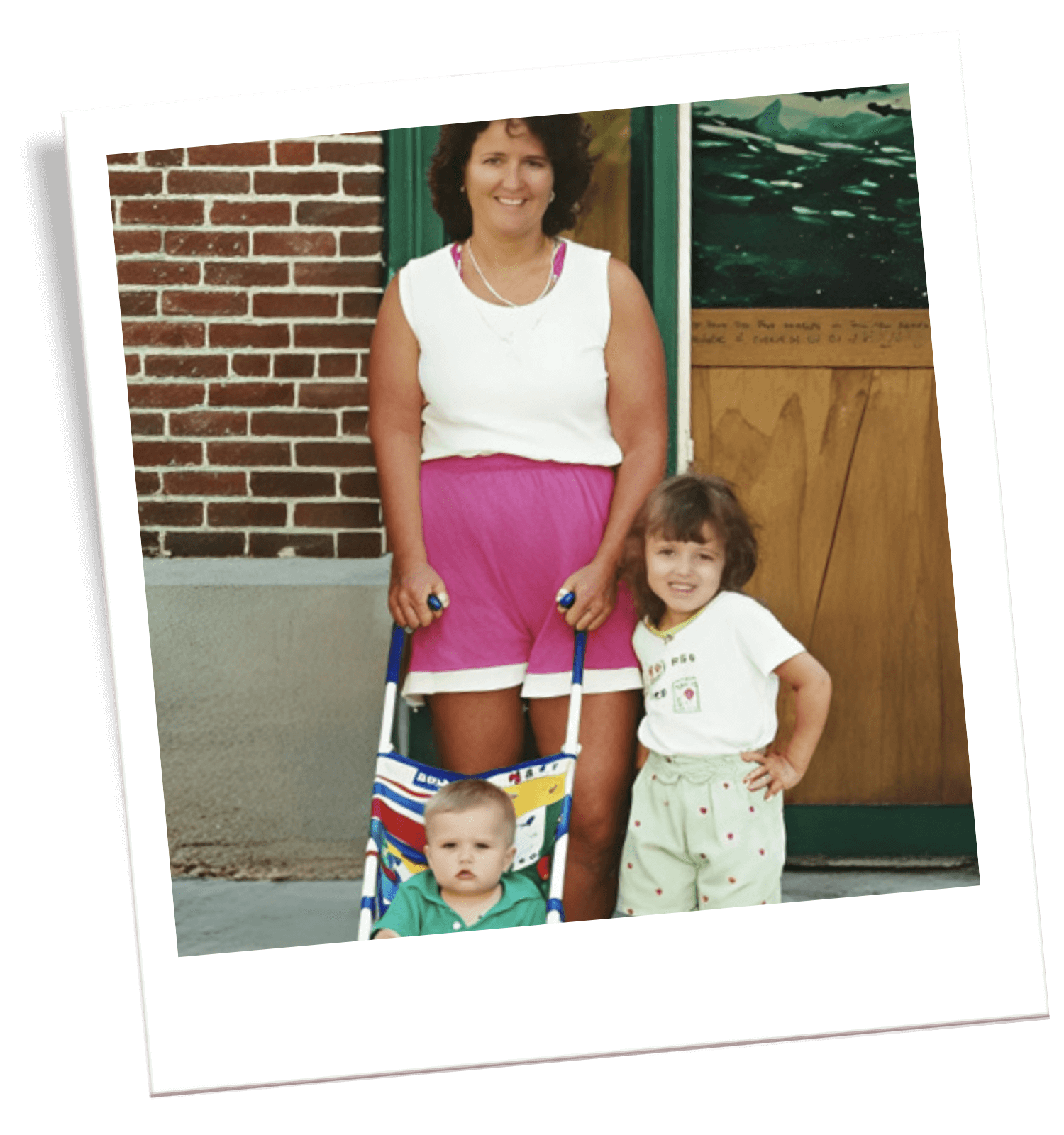 Woman with two children outside a building.