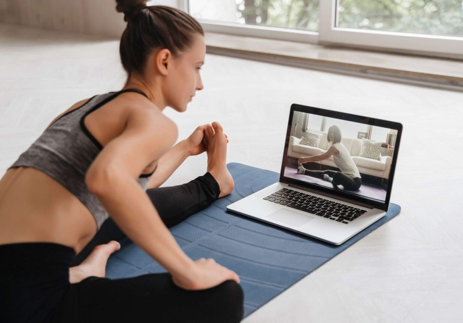 Woman practicing yoga with online class.